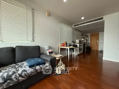 Spacious living room with wooden flooring and modern decor in a cozy apartment.