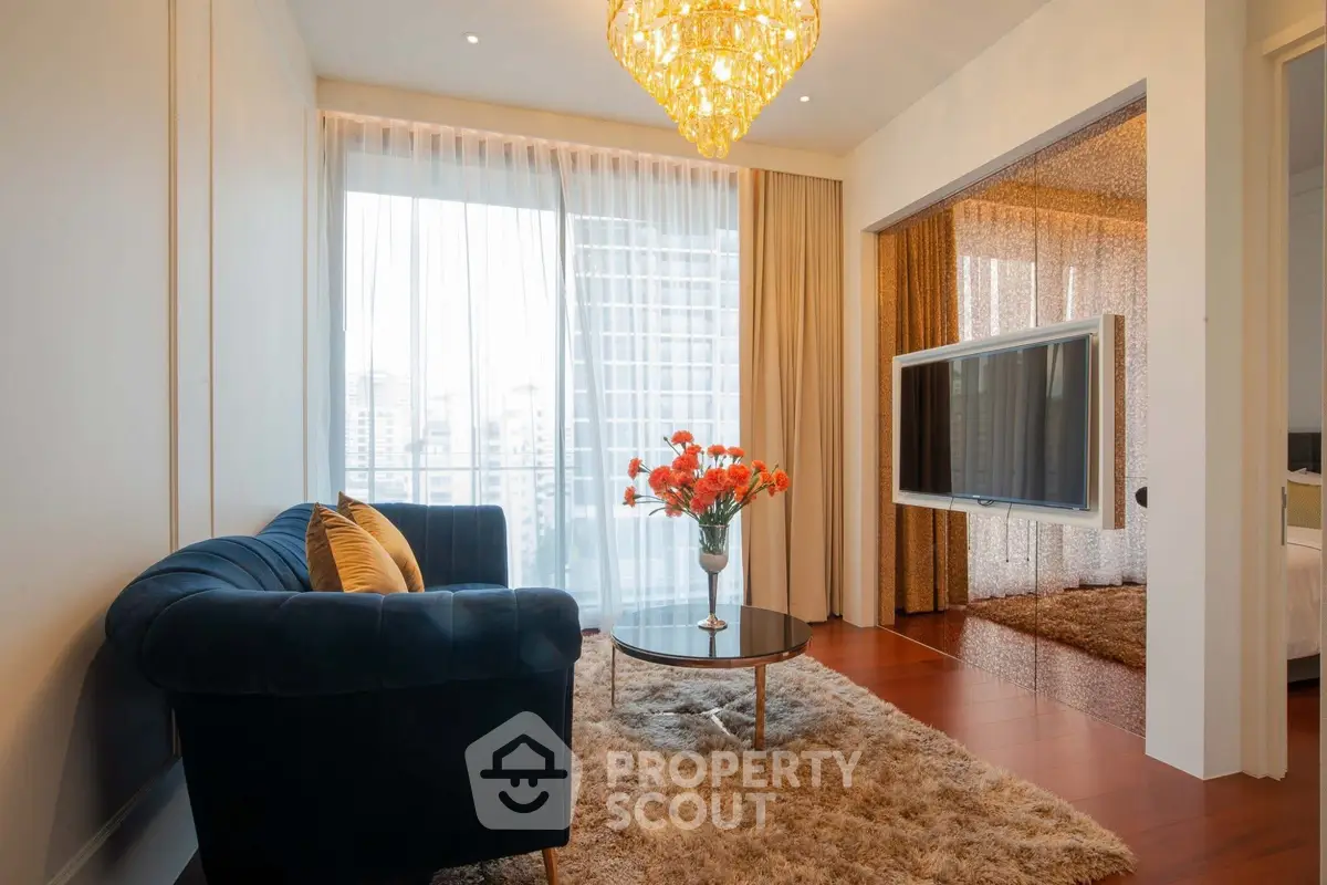 Luxurious living room with elegant chandelier and city view, featuring plush sofa and modern decor.