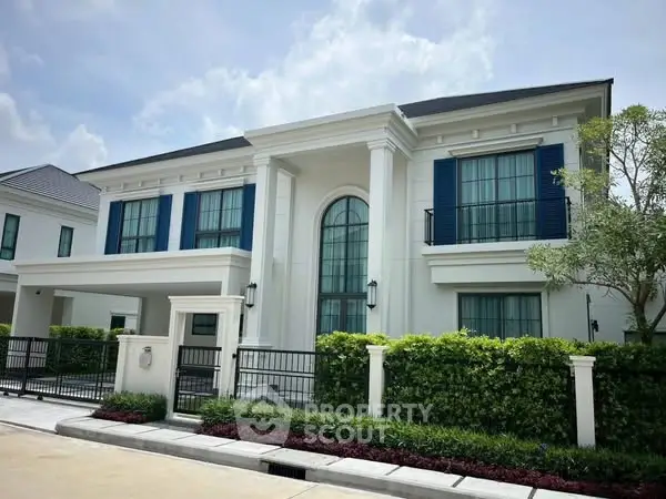 Elegant two-story house with classic architecture and lush landscaping
