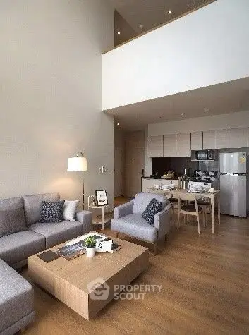 Spacious modern living room with open kitchen and stylish furniture in a high-ceiling apartment.