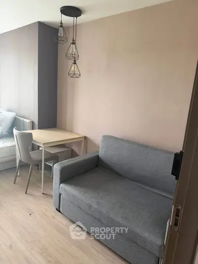 Modern living room with stylish sofa and dining area in cozy apartment.