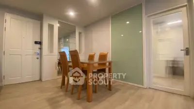 Modern dining area with wooden table and chairs, featuring sleek design and ambient lighting.