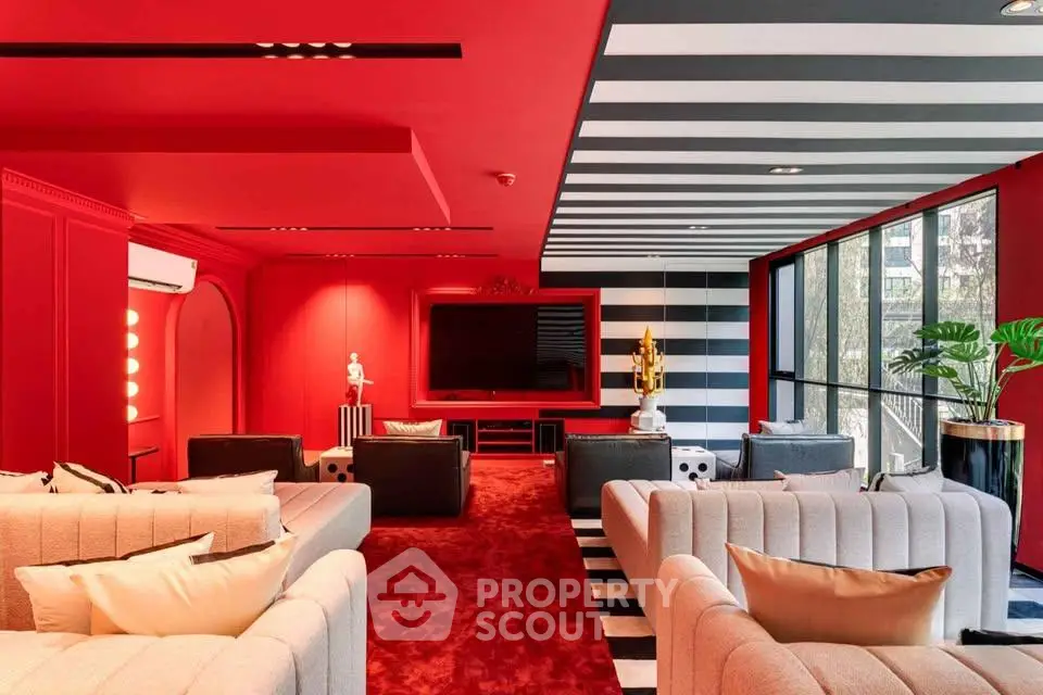 Luxurious modern living room with bold red and black design, plush seating, and large windows.