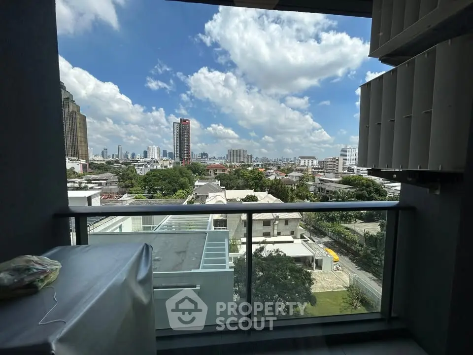 Stunning cityscape view from a modern balcony with glass railing, perfect for urban living.