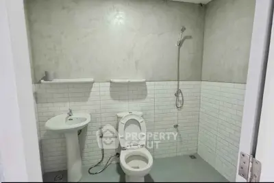 Modern minimalist bathroom with white tiles and open shower design.