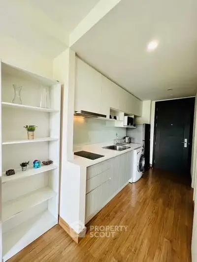 Modern kitchen with sleek cabinetry and built-in appliances in a compact layout.
