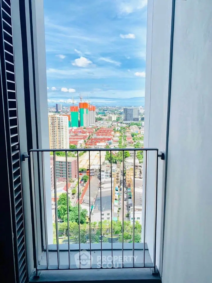 Stunning high-rise city view from a balcony with clear blue skies.