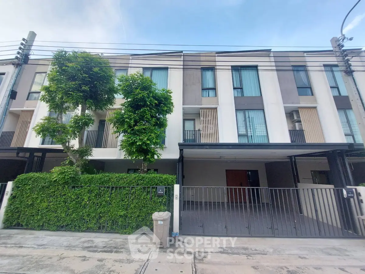 Modern townhouse exterior with sleek design and lush greenery, perfect for urban living.
