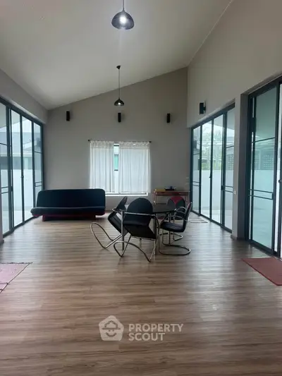 Spacious modern living room with high ceilings and large windows, perfect for natural light and contemporary living.