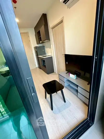 Modern compact living room with kitchenette and sleek furniture