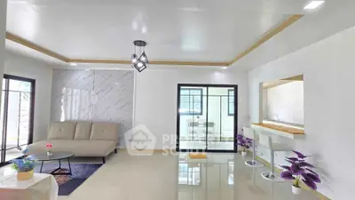 Modern open-plan living room with sleek design and stylish furniture, featuring a cozy sofa and elegant lighting.