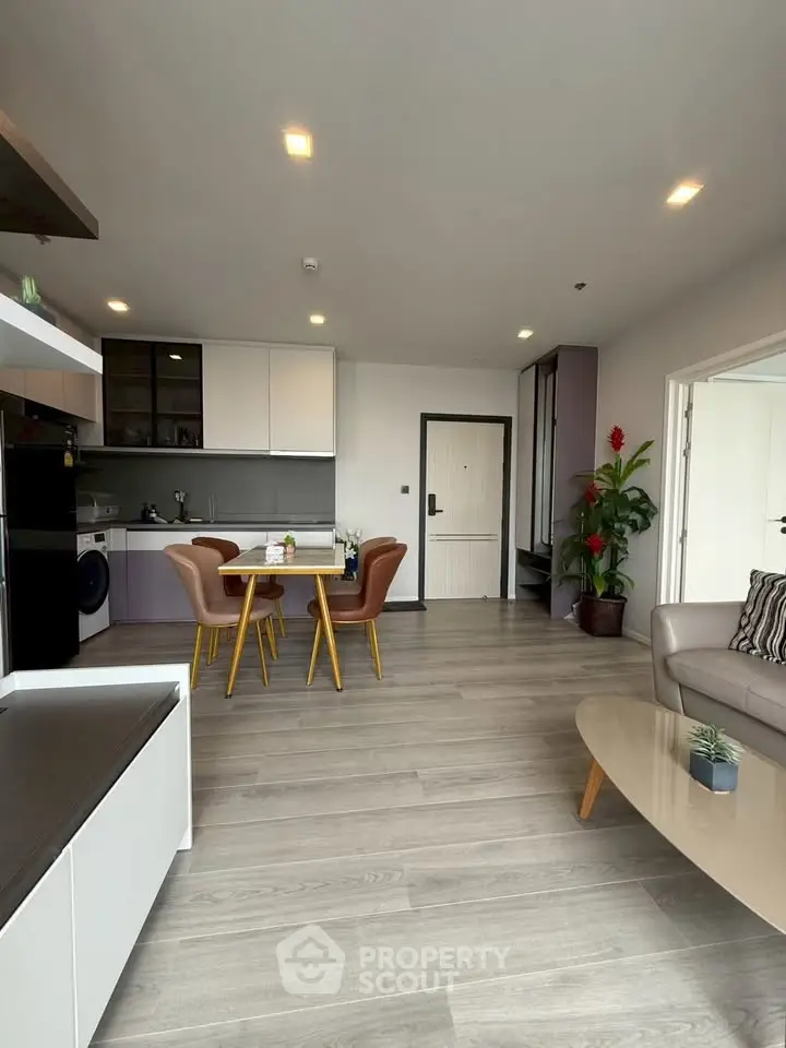 Modern open-plan living room with stylish furniture and sleek kitchen design.
