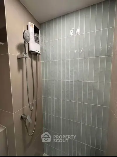 Modern bathroom shower area with sleek tiled walls and contemporary fixtures.