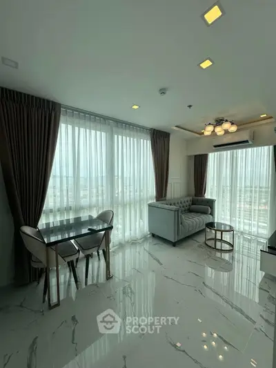 Modern living room with large windows and elegant furniture, offering a bright and airy atmosphere.