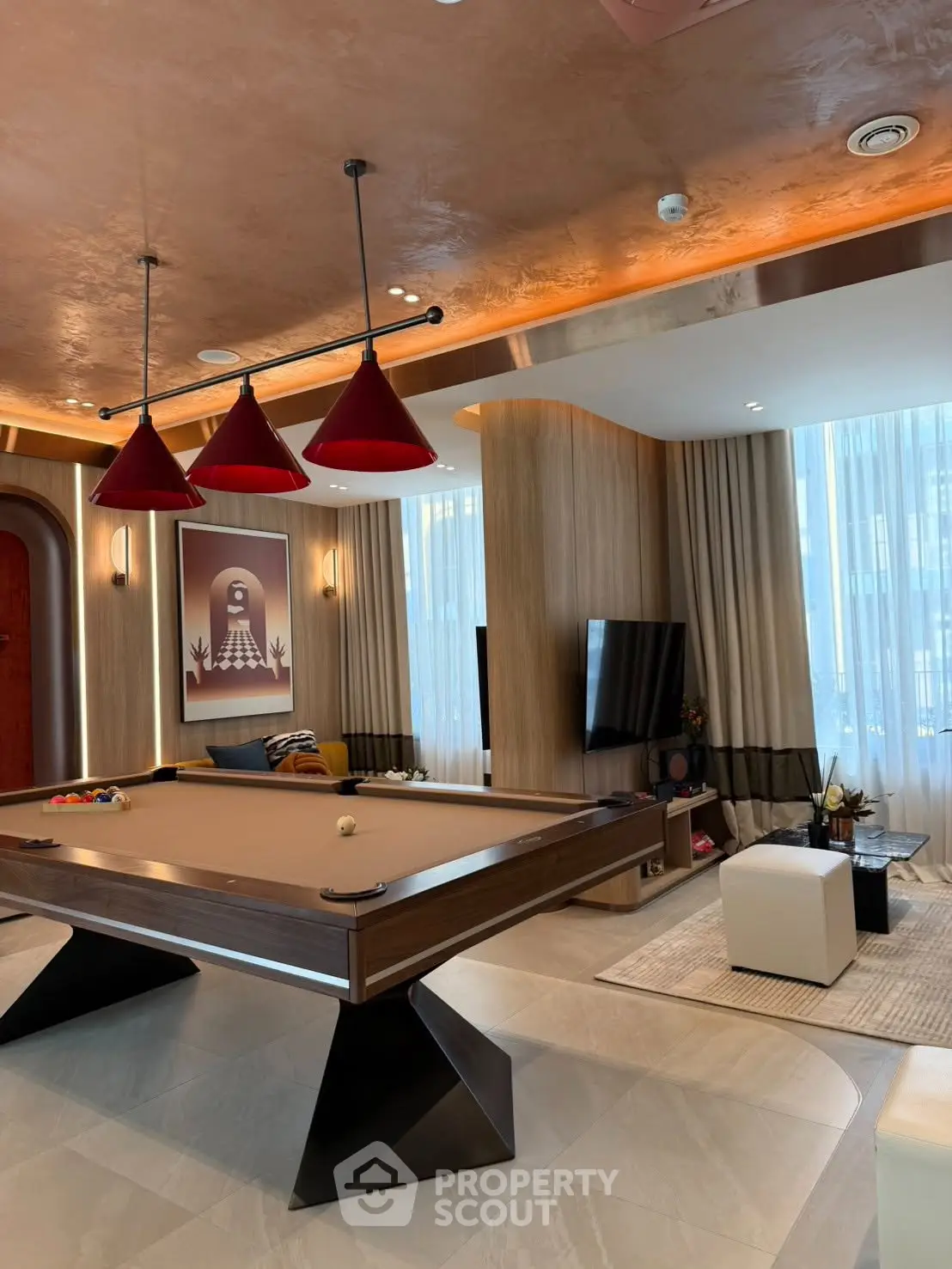 Luxurious living room with pool table and modern decor, featuring elegant lighting and stylish furnishings.
