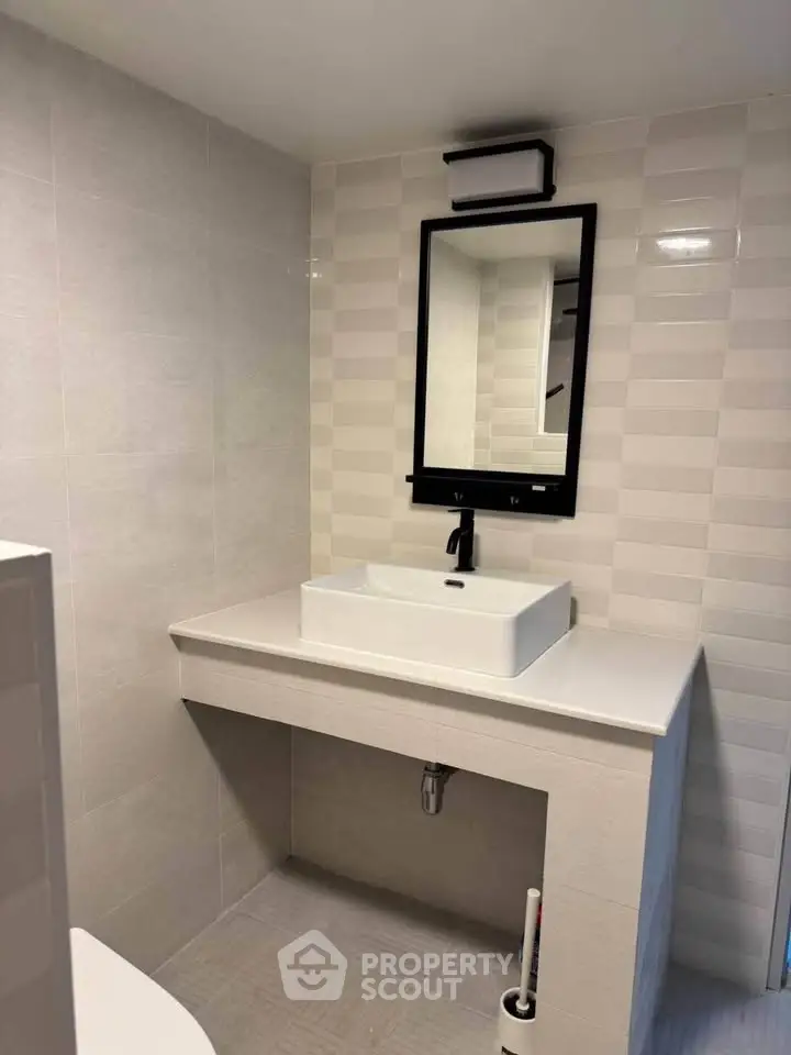 Modern bathroom with sleek sink and stylish mirror in contemporary design.