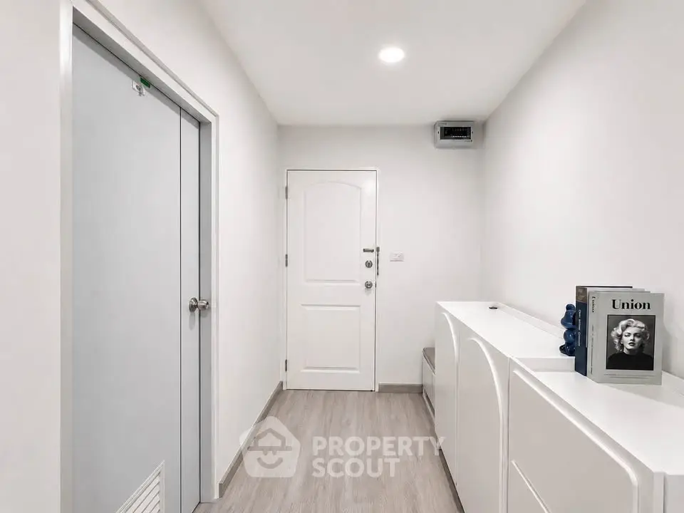 Modern minimalist hallway with white doors and sleek storage units