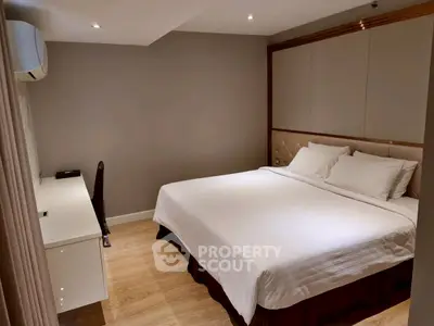 Modern bedroom with cozy bed and study desk, perfect for relaxation and productivity.