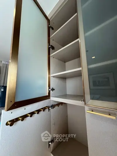 Elegant storage cabinet with open shelves and brass accents in modern interior.