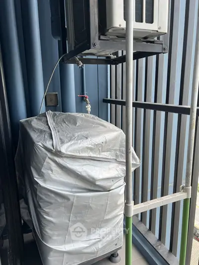 Compact balcony with covered air conditioning unit and modern railing design.