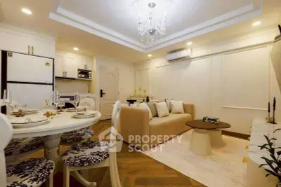 Elegant living room with open kitchen, featuring chic decor and modern lighting.