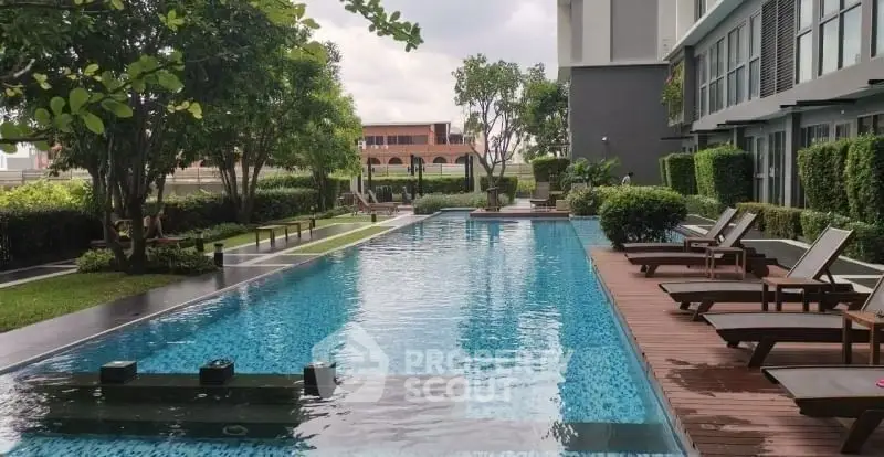 Luxurious apartment complex with stunning outdoor pool and lush greenery.