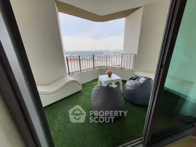 Charming balcony with artificial grass, cozy seating, and panoramic city view.