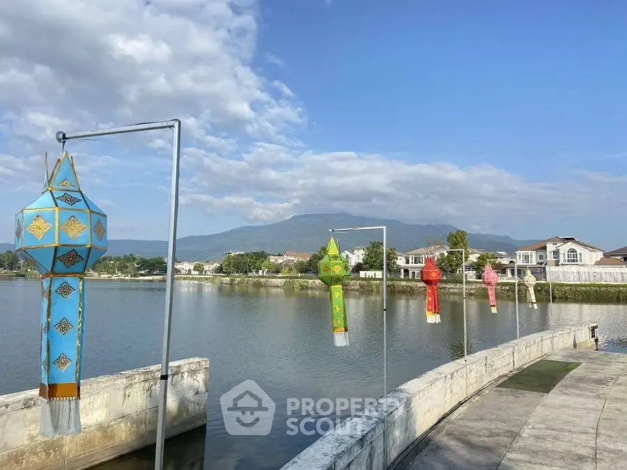Scenic lakeside view with colorful lanterns and mountain backdrop, perfect for tranquil living.
