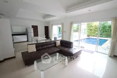 Spacious living room with pool view, modern furniture, and open layout in luxury home.