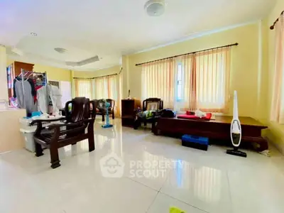 Spacious living room with natural light and elegant wooden furniture.