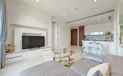Modern living room with sleek design and open kitchen layout, featuring a cozy seating area and stylish decor.