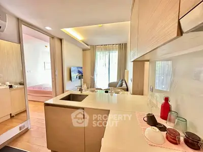 Modern open-layout kitchen with sleek design and cozy living area in a stylish apartment.