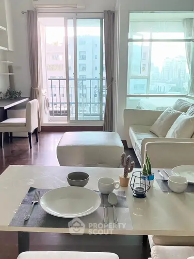 Bright and airy living room with modern decor and city view balcony.