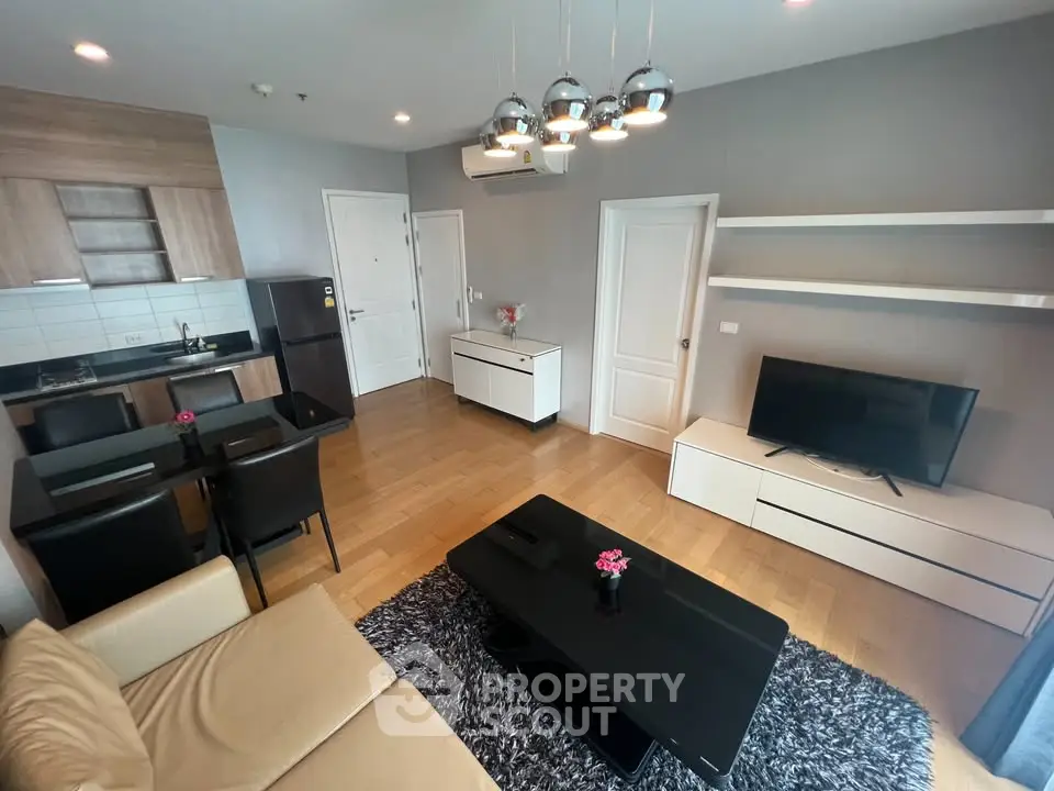 Modern living room with open kitchen, sleek furniture, and stylish decor in a contemporary apartment.