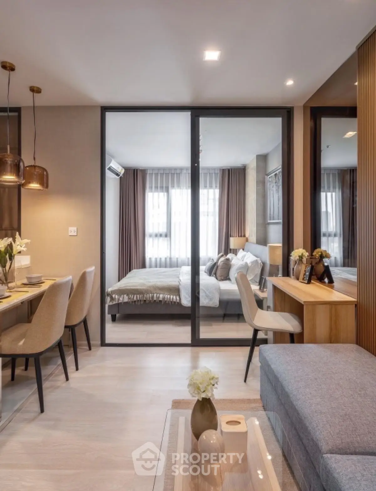 Modern open-plan living room with dining area and bedroom view