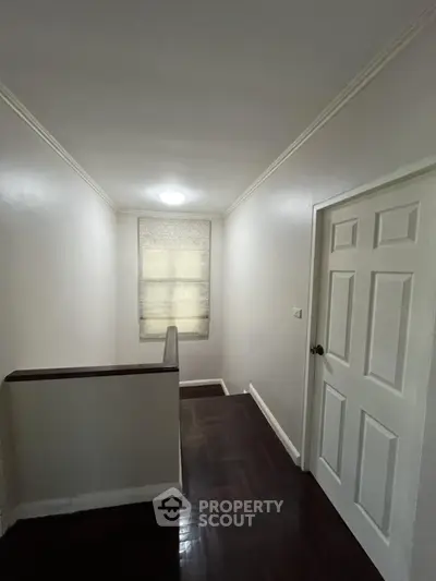 Minimalist hallway with wooden flooring and natural light