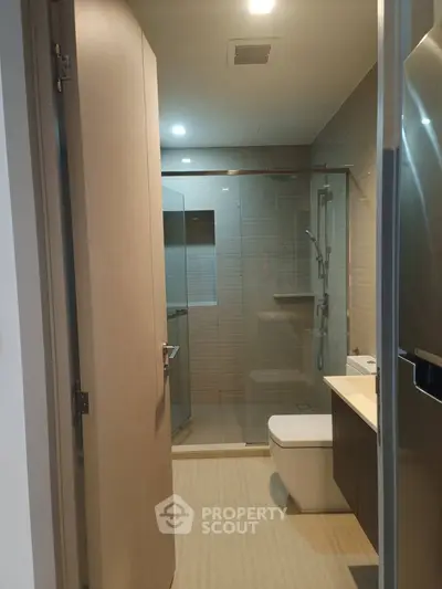 Modern bathroom with glass shower and sleek fixtures in a contemporary apartment.