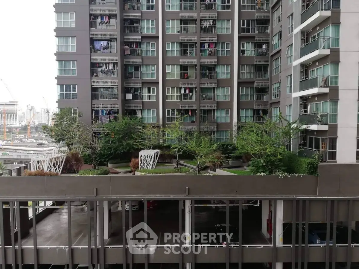Modern urban apartment building with lush green rooftop garden and city view.