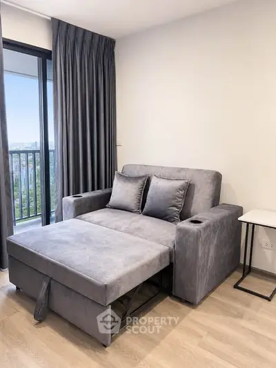 Modern living room with stylish gray sofa bed and balcony view