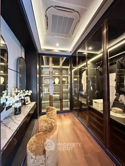 Luxurious walk-in closet with elegant lighting and modern design, featuring ample storage and stylish decor.