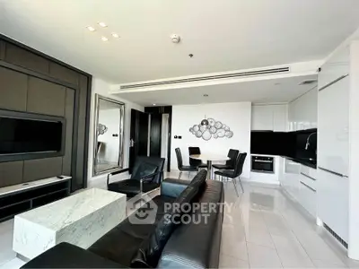 Modern living room with sleek black and white decor, open kitchen layout, and elegant dining area.