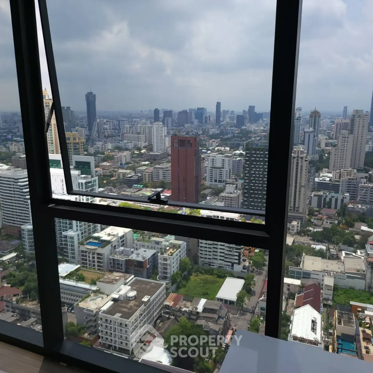 Stunning cityscape view from high-rise apartment window showcasing urban skyline.