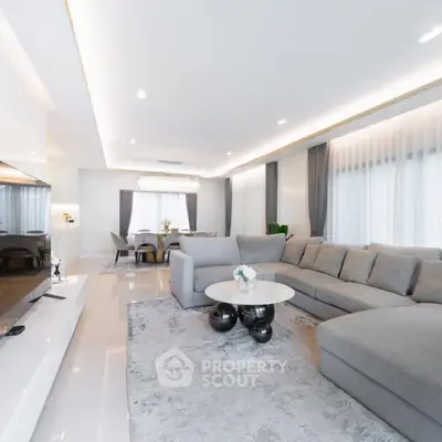Luxurious modern living room with spacious gray sectional sofa and elegant dining area.