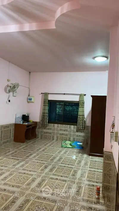 Spacious room with tiled flooring and window view, ideal for versatile use.