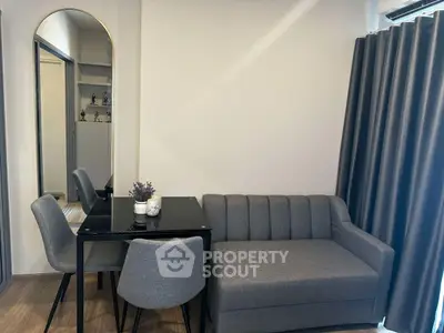 Modern living room with stylish grey sofa and dining set, perfect for cozy gatherings.
