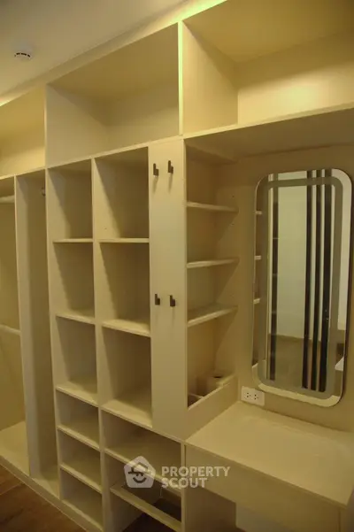 Spacious walk-in closet with ample shelving and built-in mirror