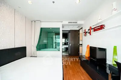 Modern bedroom with sleek decor and open layout featuring a bathtub view.