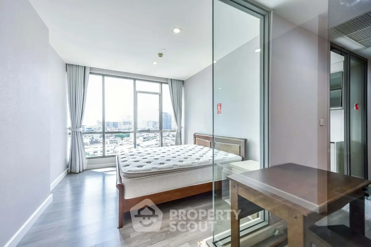 Spacious bedroom with city view and modern glass partition, featuring a comfortable bed and elegant decor.