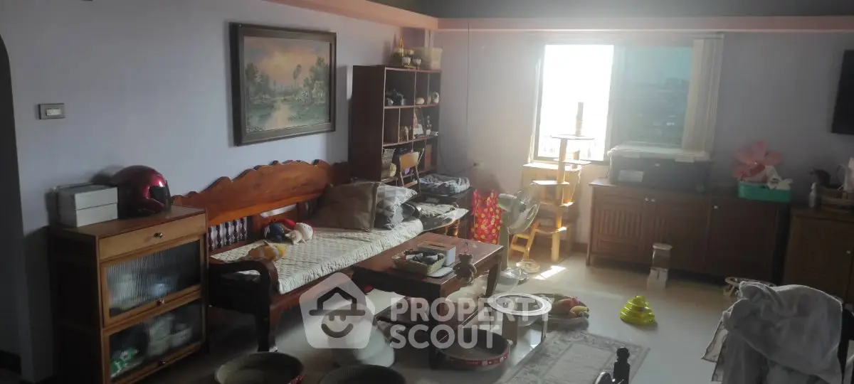 Cozy living room with natural light, wooden furniture, and decorative elements, perfect for relaxation.