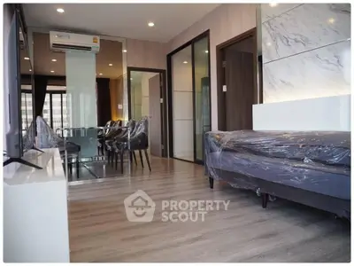 Modern living room with dining area, featuring sleek furniture and elegant decor.